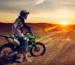 Dirt bike rental Dubai rider jumping over red sand dunes at sunset